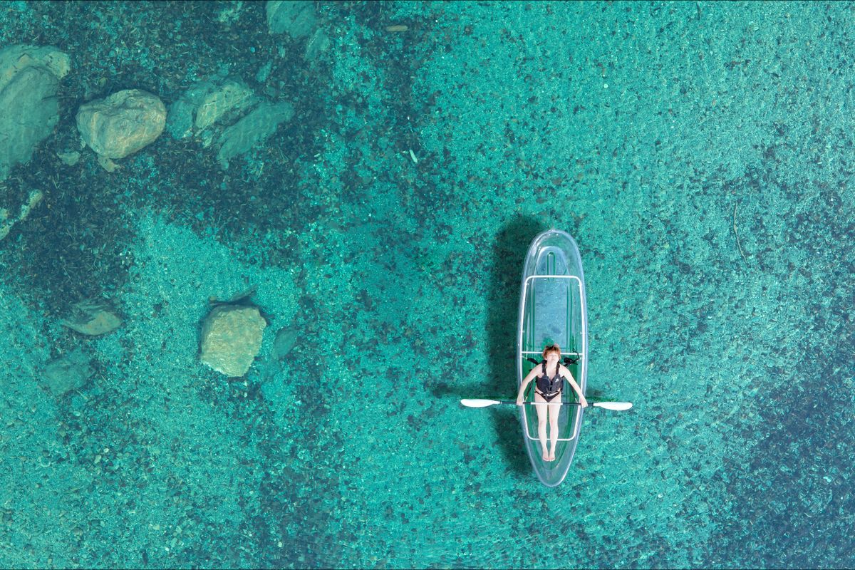 Clear kayak floating in transparent turquoise water